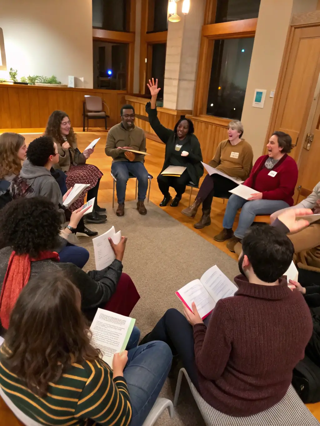 A group of people are gathered in a community space, participating in a book discussion led by a facilitator. The atmosphere is lively and engaging, showcasing the intellectual stimulation and social interaction provided by the program.